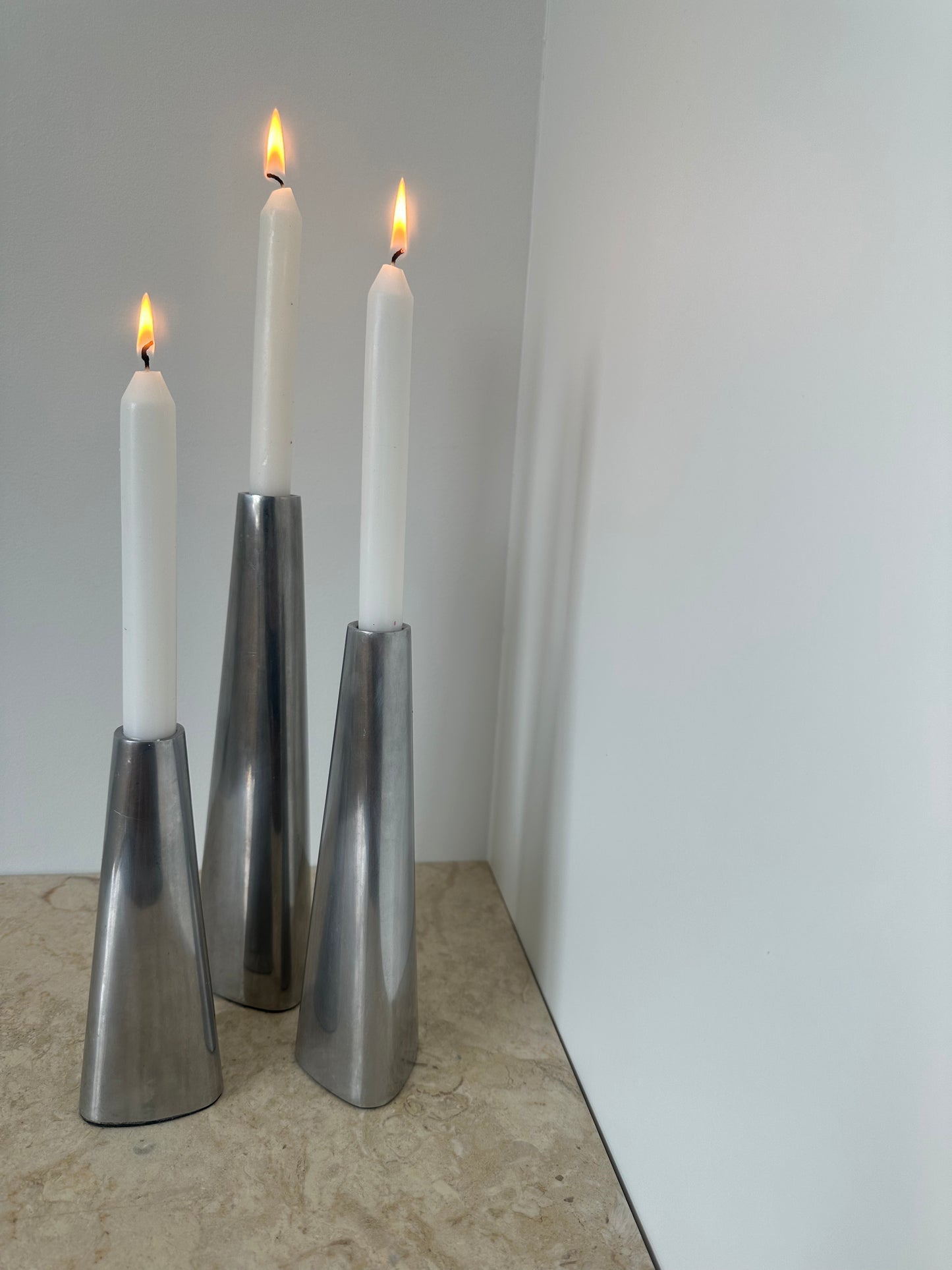 Three silver candleholders