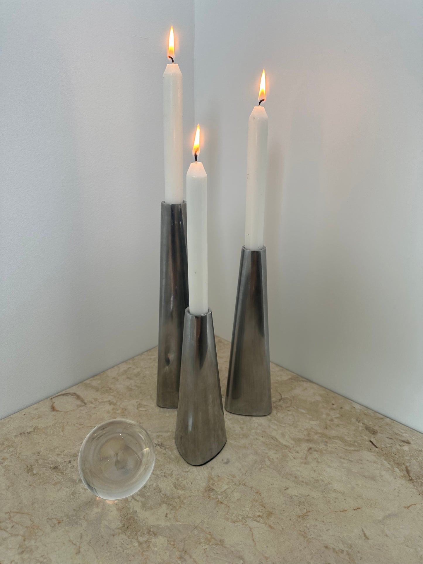 Three silver candleholders