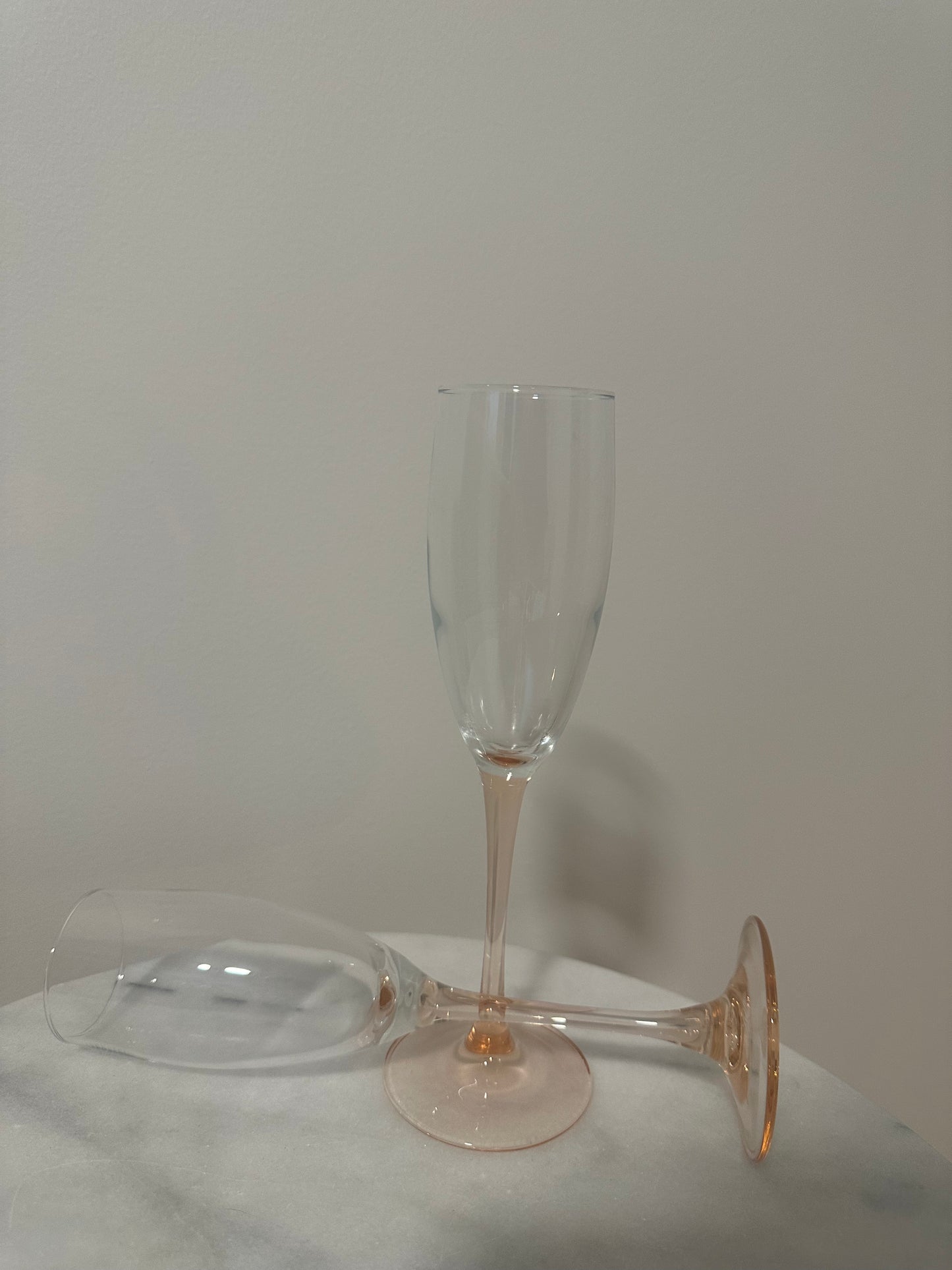 Two pink stem champagne glasses